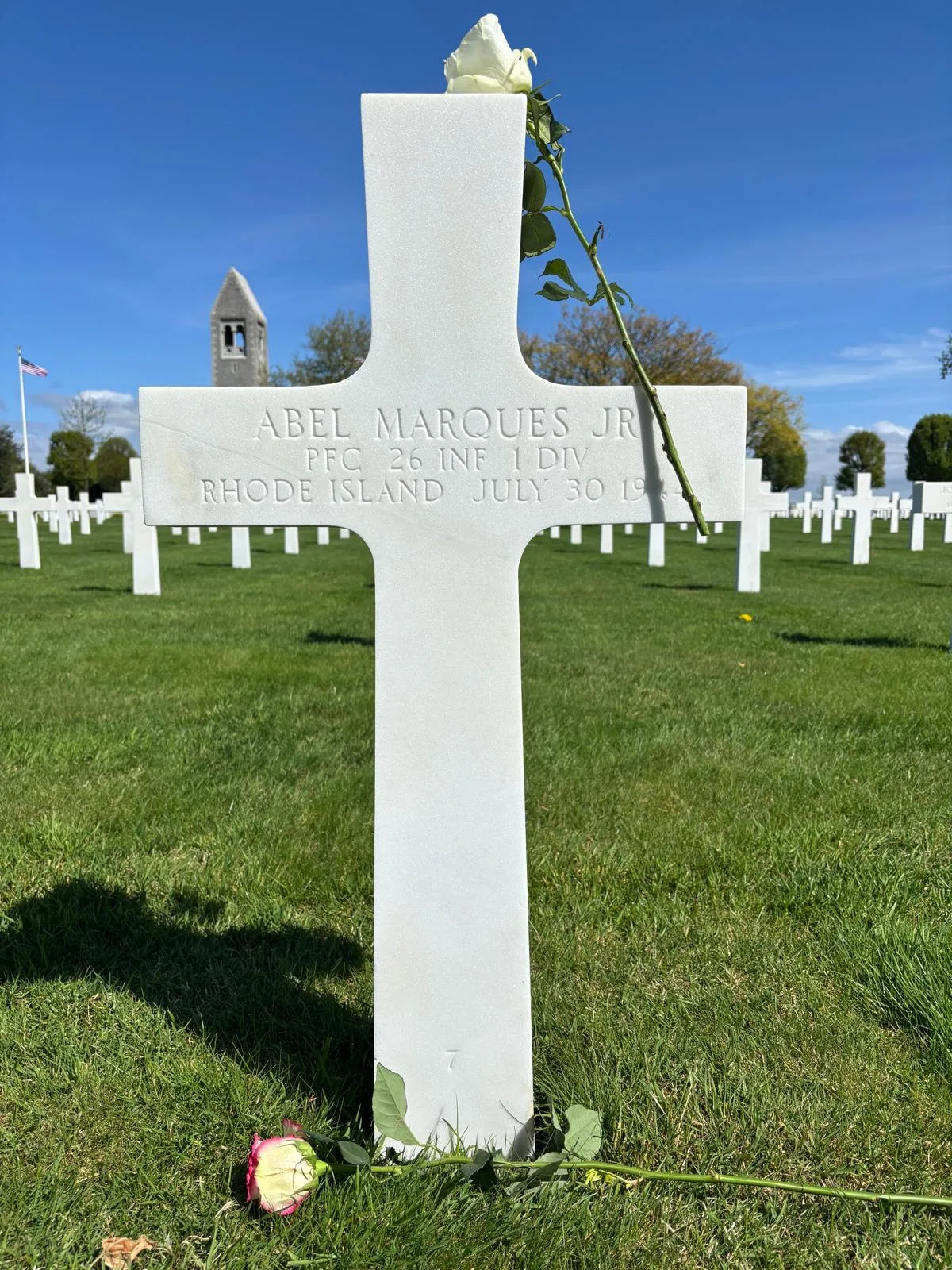 Abel Marques Jr's grave at the Brittany American Cemetery in Saint James, with the memorial chapel visible in the background