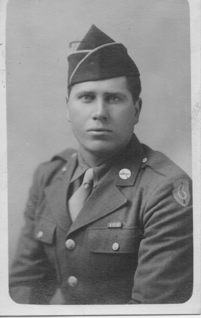 Studio portrait of Henry "Hank" Dombrowski in his U.S. Army uniform, wearing the 8th Infantry Division shoulder patch
