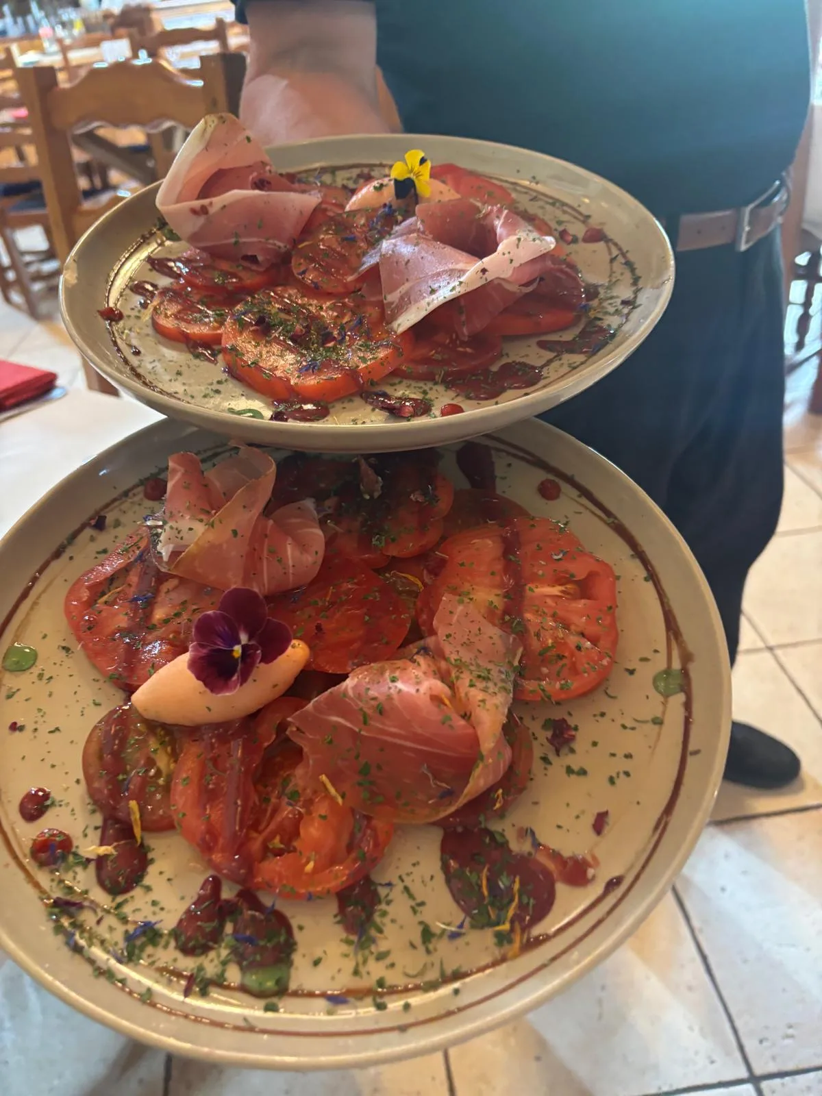 Carpaccio of heirloom tomatoes with a veil of aged country ham, herbs and edible flowers