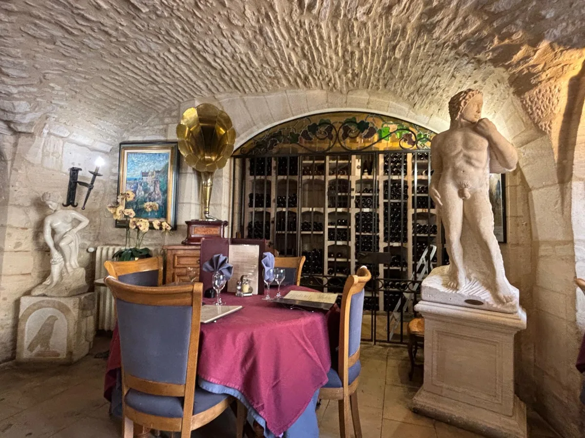 Wide view of the cellar dining room with statues and gramophone