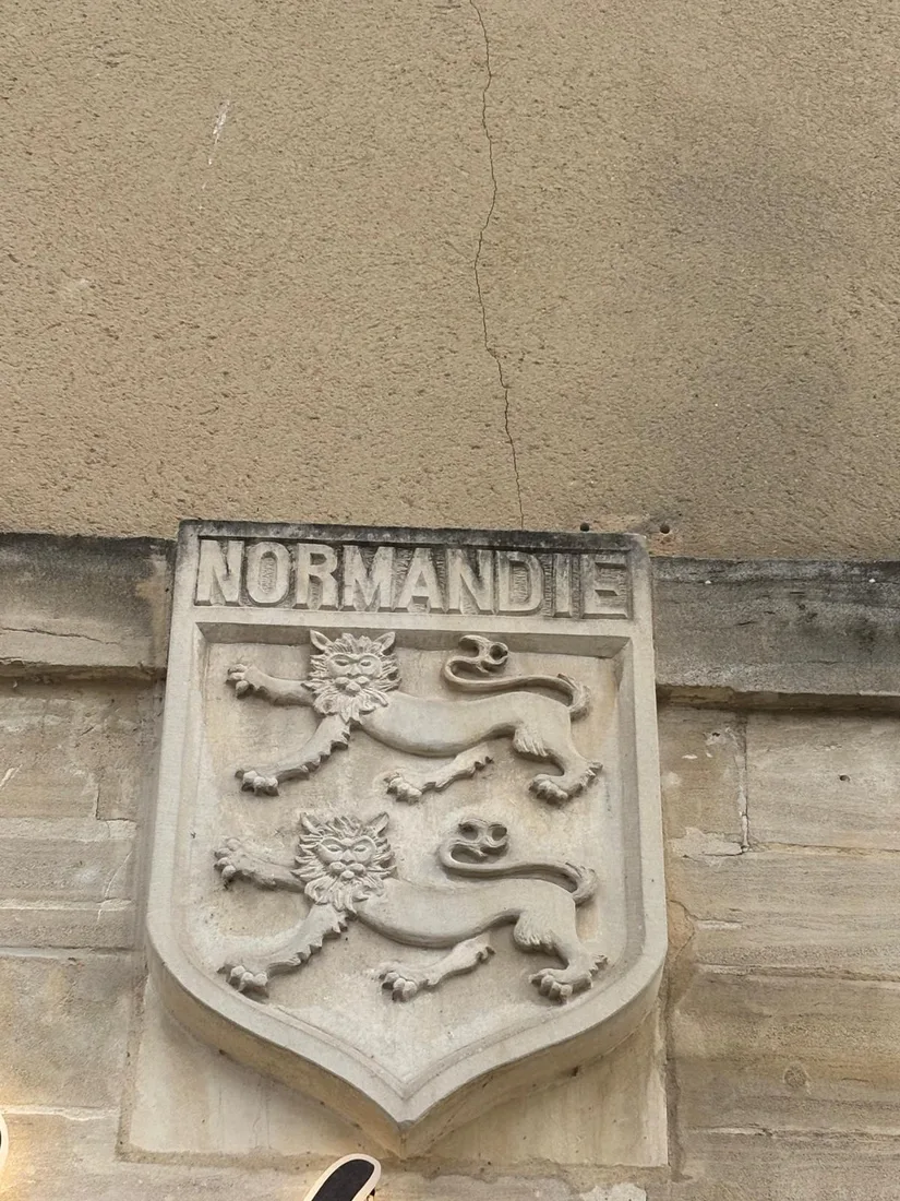 The two leopards of Normandy carved in stone above the restaurant sign