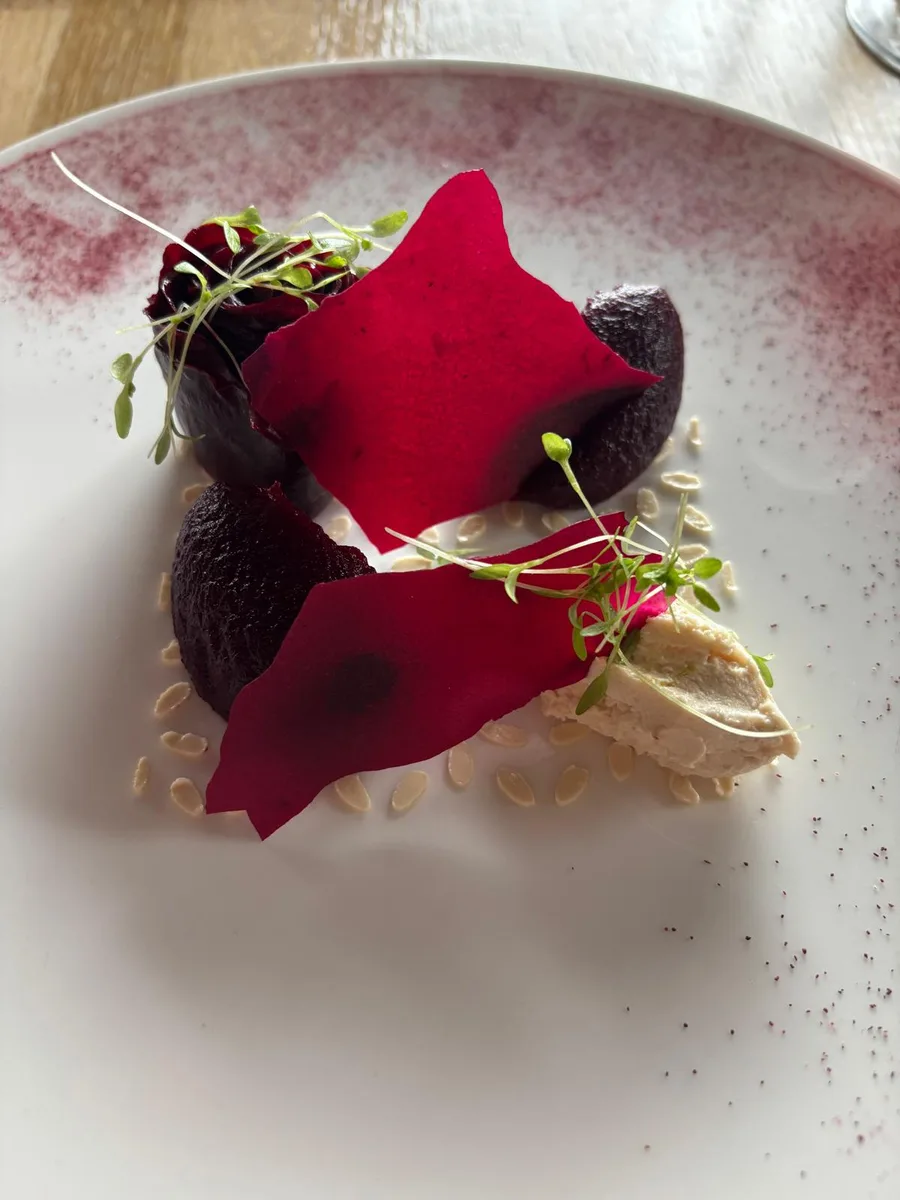 Beetroot dish with vibrant crimson petals and microgreens
