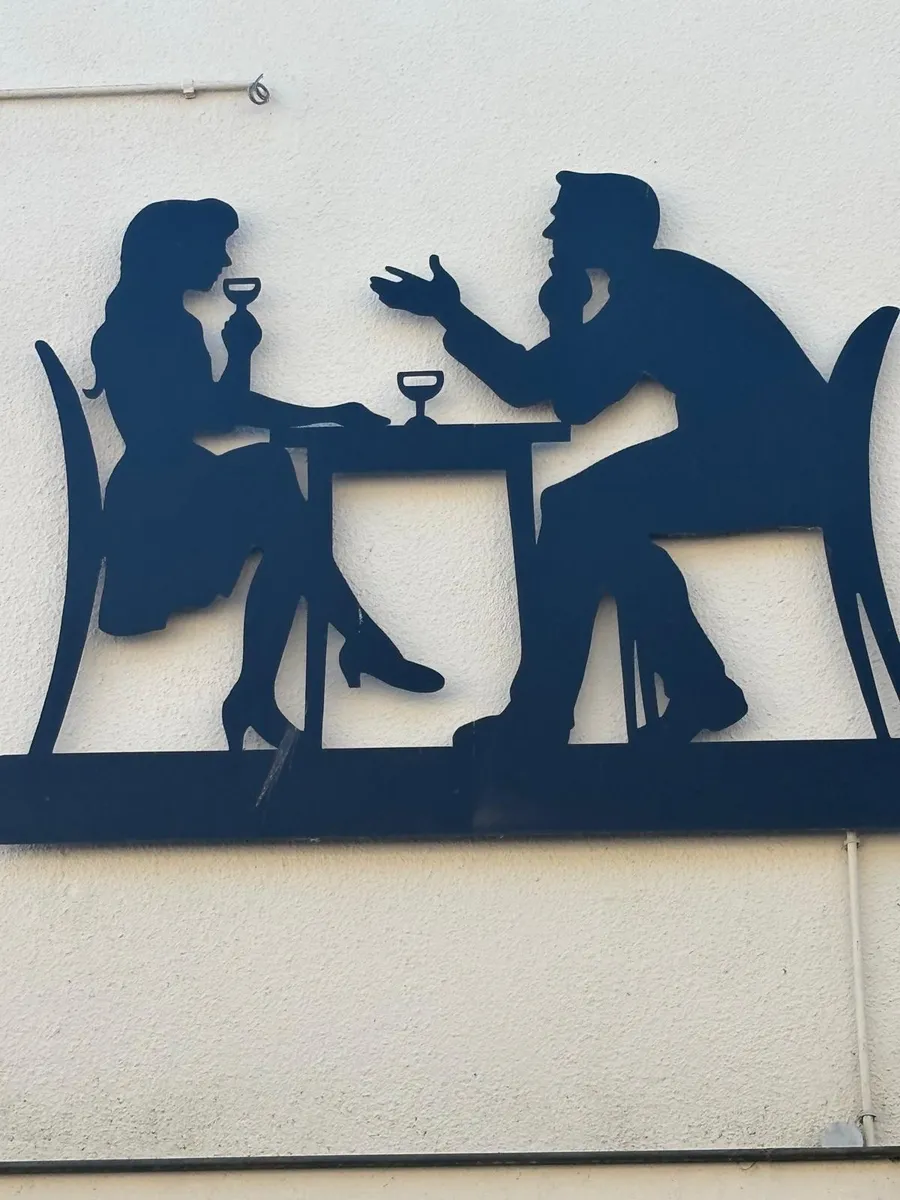 Metal silhouette artwork of a couple dining together