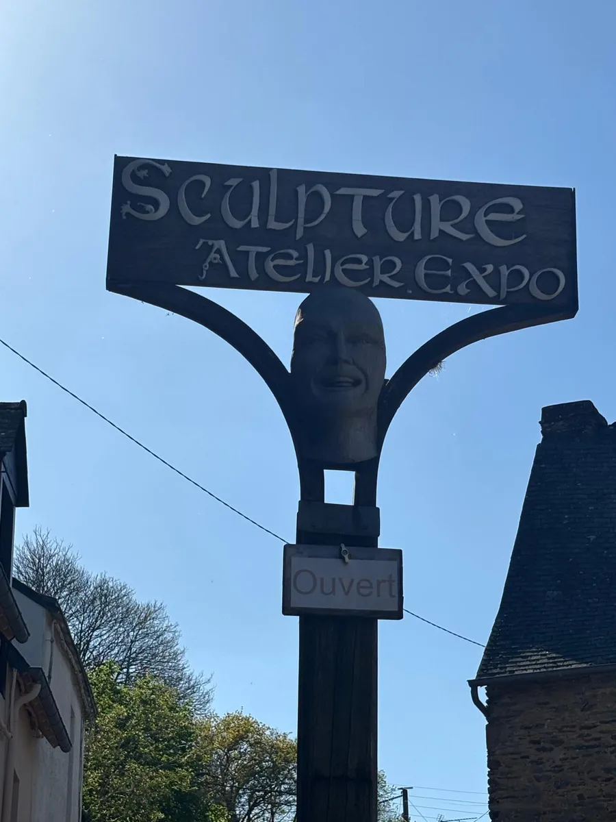 Carved wooden sculpture sign reading Sculpture Atelier Expo